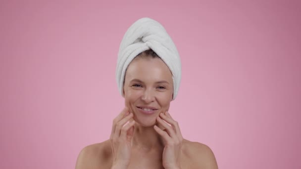 抗水肿按摩器快乐中年妇女洗澡后做面部按摩 微笑着在粉红工作室的背景上拍照 慢动作 — 图库视频影像