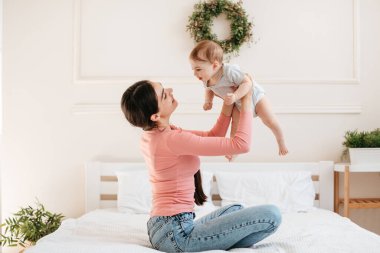 Dünyanın en büyük aşkı. Mutlu anne, sevimli küçük kızıyla oynarken onu havaya kaldırıyor, çocuğuyla evde vakit geçiriyor.