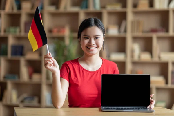Cieszę Się Nastoletnia Chińska Dziewczyna Trzymać Flagę Niemiec Przy Stole — Zdjęcie stockowe