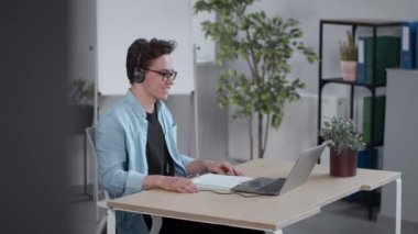 Çevrimiçi iletişim. Genç, pozitif çocuk, bilgisayar aracılığıyla öğretmenle video sohbeti ev ofisinde uzaktan çalışma, çekim takip etme, yavaş çekim.