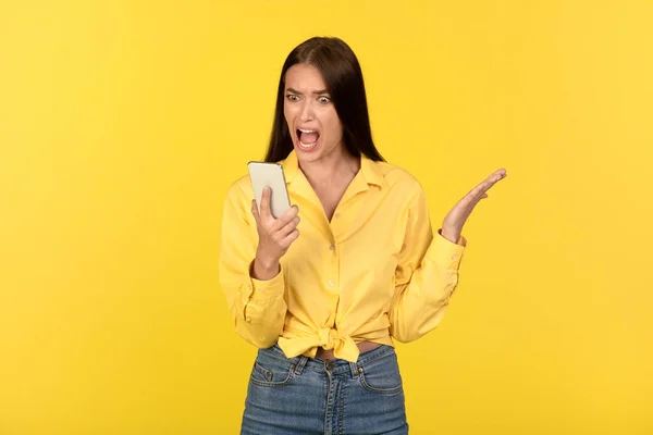 Arga Lady Ropande Håller Smartphone Läsa Negativt Meddelande Stående Gul — Stockfoto