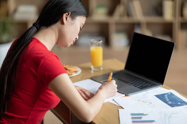 Mujer China Adolescente Grave Haciendo Notas Mesa Con Ordenador Portátil — Foto de Stock