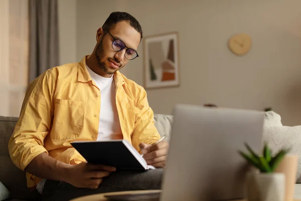 Konzentrierter Junger Afroamerikanischer Mann Mit Laptop Online Arbeit Notizen Während — Stockfoto