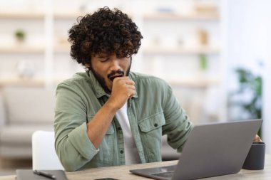 Uykucu, koyu tenli, kıvırcık saçlı, ofiste dizüstü bilgisayarın önünde oturan, esneyen, çalışan ya da serbest çalışan, iş yerinde patinaj çeken, yer kopyalayan,