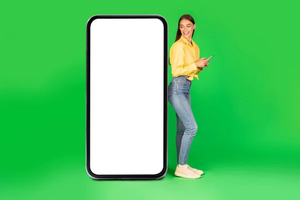 Kvinna Med Mobiltelefon Stående Nära Stor Smartphone Med Blank Screen — Stockfoto