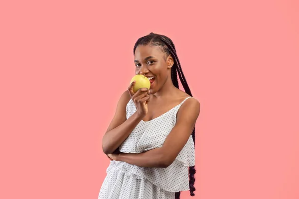 Γοητευτική Νεαρή Αφροαμερικανή Που Τρώει Ώριμο Πράσινο Μήλο Ροζ Φόντο — Φωτογραφία Αρχείου