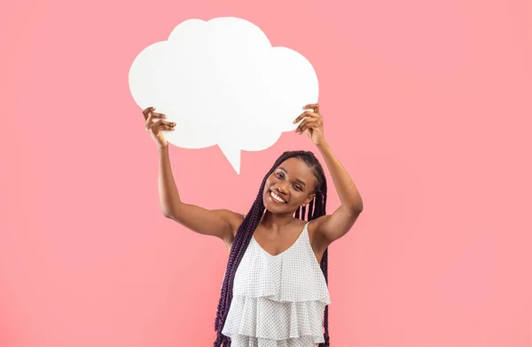 快乐的年轻非洲裔美国女人抱着空洞的语音泡沫 模仿粉红工作室的背景 迷人的千年黑人女士用空白的文字云彩为广告提供空间 — 图库照片