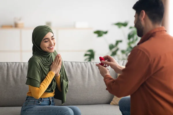 快乐的穆斯林男人在希吉布向女人求婚 站在一个膝盖上 戴着订婚戒指的礼盒 浪漫的求婚 婚姻的概念 选择性焦点 — 图库照片
