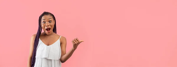 真酷的提议令人惊讶的年轻黑人女士指着粉红工作室背景的空旷空间 兴奋的非洲裔美国妇女展示广告或促销文字 — 图库照片