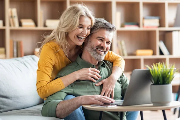 Gülümseyen Orta Yaşlı Eşler Oturma Odasında Dizüstü Bilgisayar Kullanıyor Mutlu — Stok fotoğraf