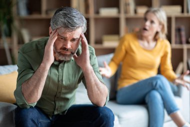 Erkekler Orta yaş krizi. Stresli Ortaçağ Erkeği Karısıyla tartıştıktan sonra Üzgün Oturuyor, Pahalı Olgun Adam Umutsuzca Başa Dokunuyor, Acı Çeken Depresyon ve İlişki Krizi, Seçici Odaklanma