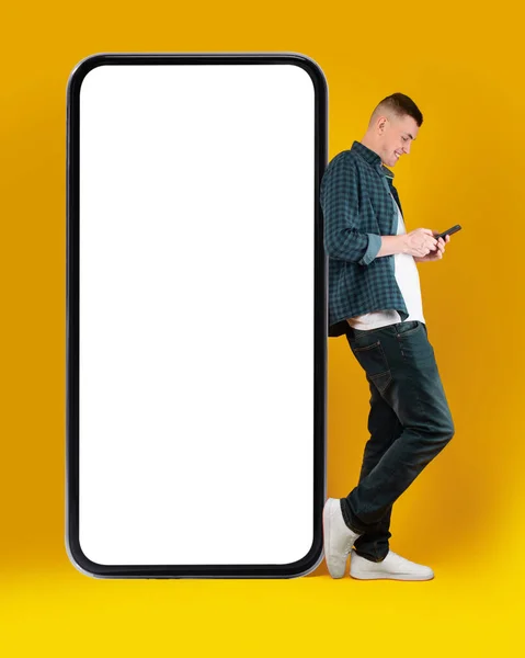 Millennium Man Using Phone Standing Lering Huge Smartphone Posing Yellow — 스톡 사진