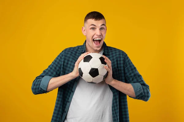 Emocjonalny Człowiek Krzyczy Holding Soccer Ball Patrząc Kamerę Świętującą Zwycięstwo — Zdjęcie stockowe