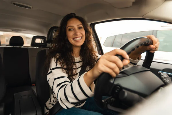 Happy Female Driver Driving Car And Smiling To Camera Posing Sitting In Seat Holding Hands On Steering Wheel In New Auto. Automobile Trip And Vehicle Ownership. Transportation Concept