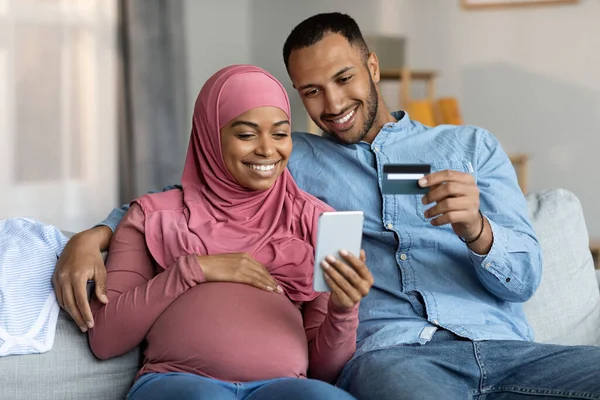 Online Πληρωμές Μαύρο Έγκυο Μουσουλμανικό Ζευγάρι Χρησιμοποιώντας Smartphone Και Πιστωτική — Φωτογραφία Αρχείου