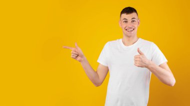 Fotokopi Uzayı 'nı işaret eden mutlu adam ve sarı stüdyonun arka planında duran harika bir teklif sunuyor. Fikri sevdim. Panorama