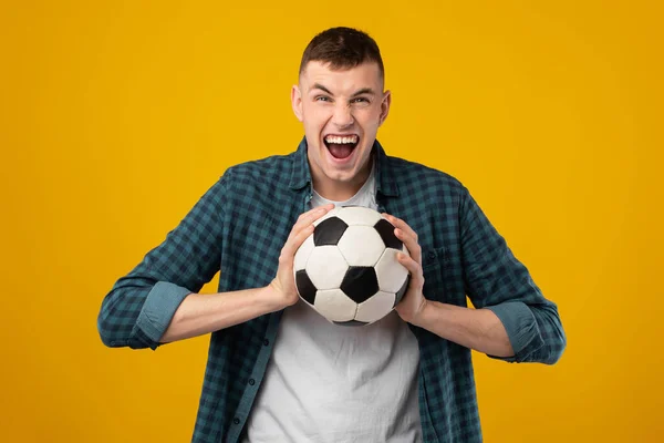 Fan Piłki Nożnej Millennial Man Trzymając Piłkę Nożną Krzycząc Emocjonalnie — Zdjęcie stockowe