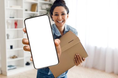 Teslimat uygulaması. Elinde paketle gülümseyen genç bir kadın boş ekranlı akıllı telefonu gösteriyor. Bin yıllık neşeli kadın kutusunu tutuyor ve boş dokunmatik ekranlı aleti gösteriyor. Kolaj.