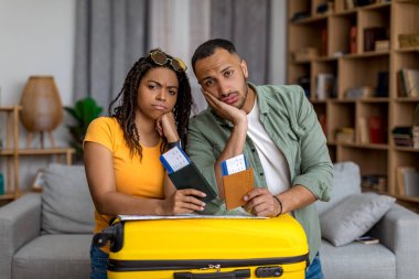 Pasaportları ve bavullarına yaslanmış uçak biletleriyle üzgün Afro-Amerikan eşleri dünya çapındaki salgın yüzünden tatillerini kaçırdılar. Karantina ve seyahat kavramı