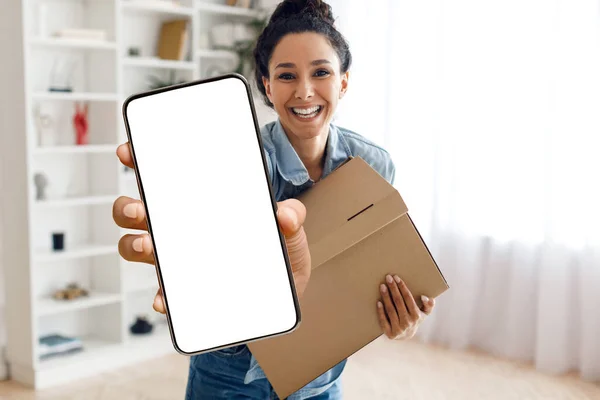 Delivery App. Smiling young woman with parcel in hand showing smartphone with blank screen for mockup, cheerful millennial female holding box and demonstrating device with empty touchscreen, collage