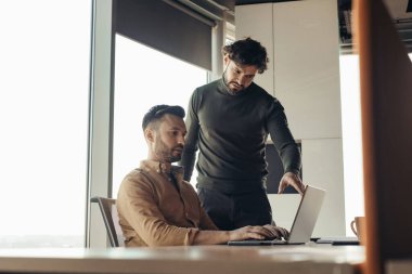 İşadamı proje detaylarını modern ofisteki bilgisayarlı çalışanına anlatıyor. Girişimciler iş toplantısı yapıyorlar, çağdaş şirketlerde yeni fikirleri tartışıyorlar.