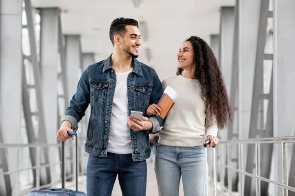 Havalimanında Elinde Akıllı Telefon Pasaportlu Neşeli Arap Eşleriyle Yürüyen Mutlu — Stok fotoğraf