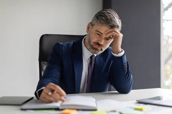 Empresario Mediana Edad Penisive Sentado Escritorio Revisando Horario Trabajo Bloc — Foto de Stock