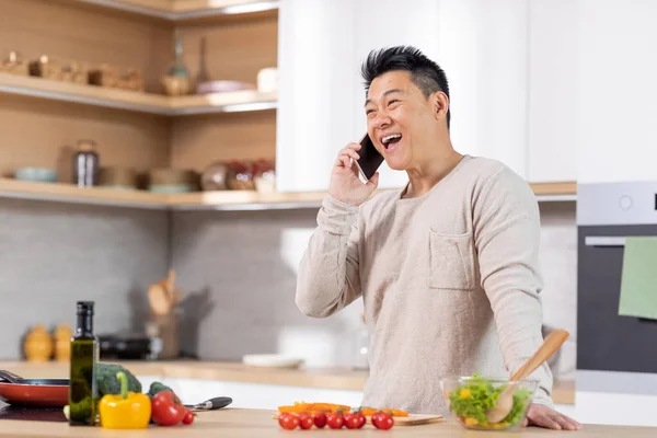 Positieve Volwassen Chinese Man Casual Outfit Naast Keukentafel Thuis Koken — Stockfoto