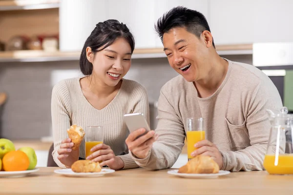 Szczęśliwa Para Azjatycka Korzystająca Telefonu Komórkowego Podczas Śniadania Kuchni Pozytywny — Zdjęcie stockowe