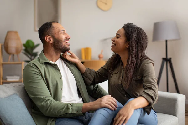 快乐的黑人夫妇坐在一起 拥抱微笑 在家里开心地在一起 千禧年的配偶们一起享受周末在索法室内享受 爱情与关系 — 图库照片