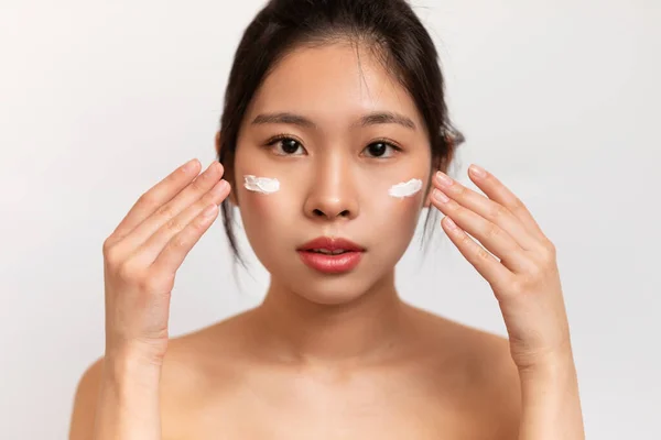 Retrato Una Hermosa Mujer Asiática Con Crema Hidratante Sus Mejillas — Foto de Stock