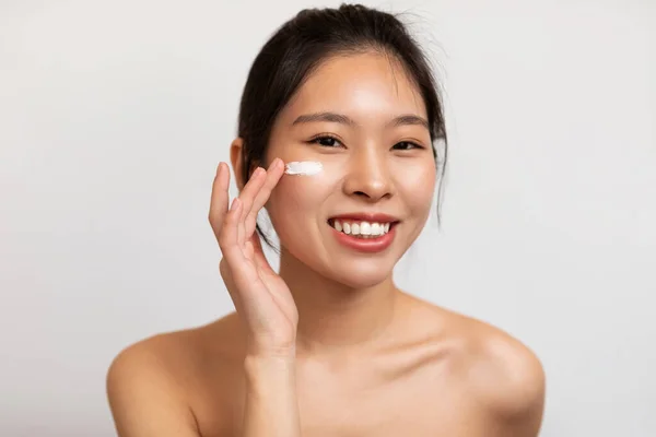 Retrato Una Joven Coreana Aplicando Crema Facial Bajo Sus Ojos — Foto de Stock
