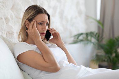 Mutsuz, uzun saçlı bir bayanın yatakta dinlenirken telefonla konuşması, sabah uyandıktan sonra sevgilisiyle konuşması, kötü haberler duyması, fotokopi odasına bakması, kafasına dokunması, yan görüş.