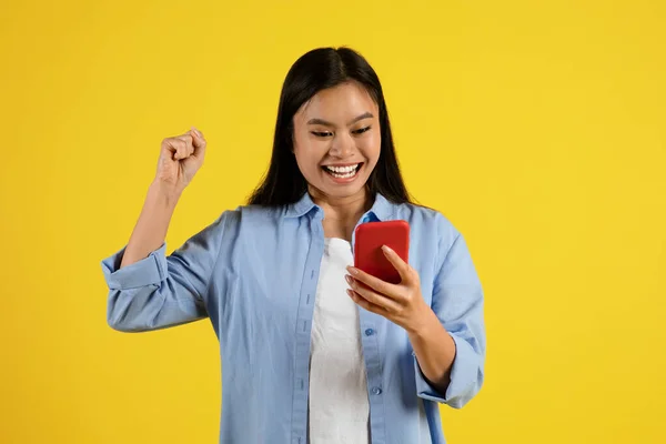 Glad Excited Young Chinese Lady Looking Smartphone Making Victory Gesture — Stock Photo, Image