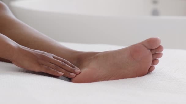 足部护理和美容 近距离拍摄的无法辨认的黑人女性在光脚上涂上护肤霜 在辛苦的一天后歇息 — 图库视频影像