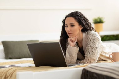 Bilgisayarlı genç bir kadın internette çalışıyor ya da ders çalışıyor, evde yatakta uzanıyor, fotokopi çekiyor. Taşınabilir bilgisayarlı ciddi bir milenyum kadını iş görüşmesi yapıyor, internette serbest çalışıyor.