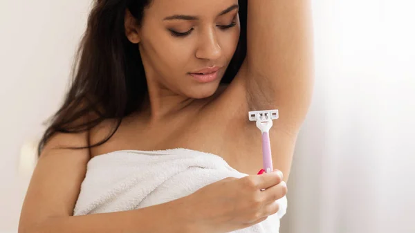 Attractive Woman Shaving Armpit With Safety Razor Making Epilation Standing In Modern Bathroom At Home. Hair Removal And Depilation Cosmetics Concept. Panorama