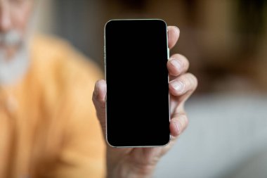 Tanımlanamayan büyükbaba yepyeni bir cep telefonu gösteriyor, içi boş, siyah bir cep telefonu, yakın plan, model. Hoş mobil teklif veya kullanıcı dostu mobil uygulama gösteren kıdemli adam kesme
