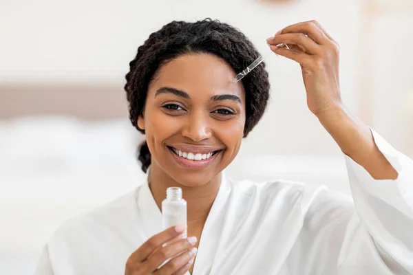 Cuidado Belleza Mujer Negra Atractiva Sonriente Aplicando Suero Facial Con —  Fotos de Stock