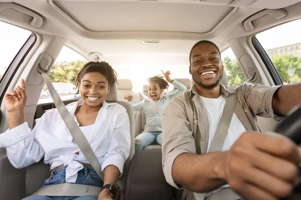 Black Family Riding Car Traveling Together In Summer, Smiling To Camera. Parents And Preteen Daughter Sitting In New Automobile. Auto Ownership And Purchase Concept. Selective Focus
