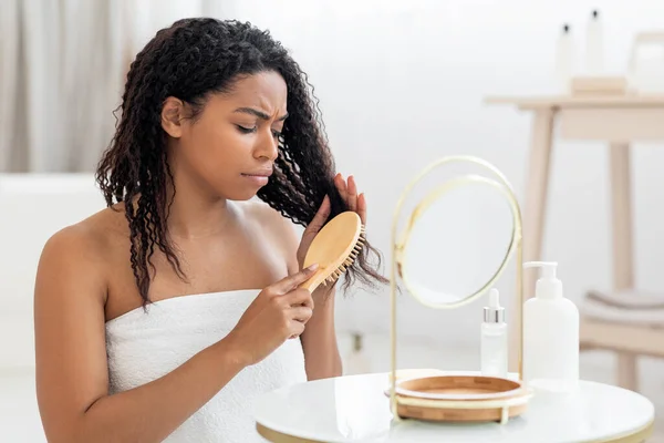 Displeased Black Woman Combing Her Tangled Hair Bamboo Brush While — Stockfoto