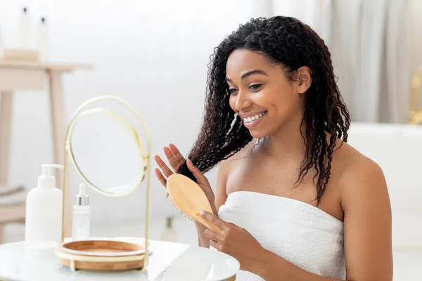 Gülümseyen Genç Siyah Kadın Banyoda Aynanın Yanında Otururken Tarağıyla Güzel — Stok fotoğraf