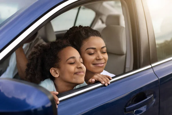 車で移動する夏の冒険を持つ家族 オープンウィンドウで新鮮な空気の匂いを味わうロードトリップを楽しんで 自動車に座っている楽しい黒い母と娘 交通概念 — ストック写真