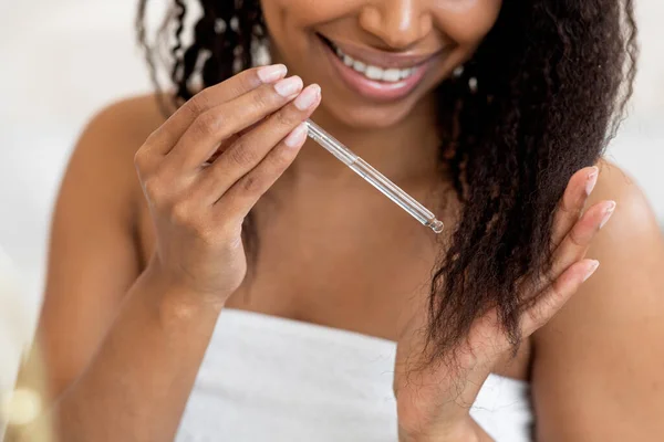 Rozszczepiona Opieka Uśmiechnięta Afroamerykanka Stosująca Olejek Nawilżający Swoich Kręconych Włosów — Zdjęcie stockowe