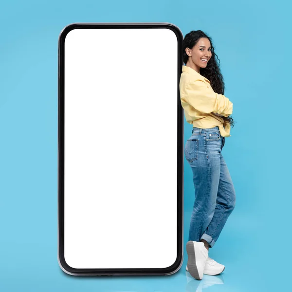 Happy Middle Eastern Woman Leaning Huge Smartphone Blank Screen Advertising — Stock Photo, Image