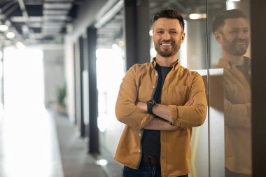 Successful Businessman Posing Crossing Hands Smiling To Camera Standing In Doorway In Modern Office. Shot Of Cheerful Entrepreneur. Business Career And Entrepreneurship Concept