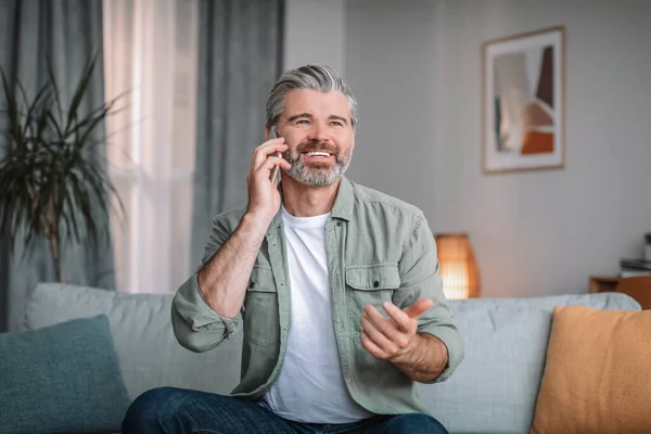 Cheerful Caucasian Senior Male Beard Calls Phone Living Room Interior — 图库照片