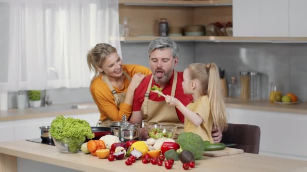 Cozinha Familiar Menina Bonito Alimentando Seu Pai Com Salada Legumes — Vídeo de Stock