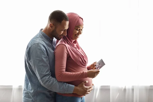 Happy Pregnant Islamic Spouses Standing Window Holding Baby Sonography Image — Foto de Stock