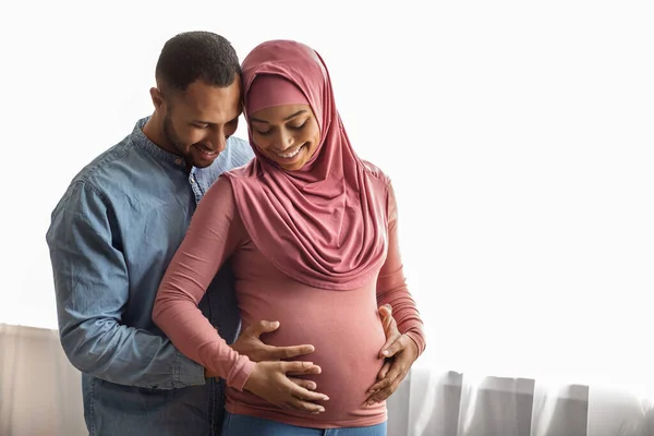 Black Husband Hugging His Pregnant Muslim Wife While Standing Window — Foto de Stock